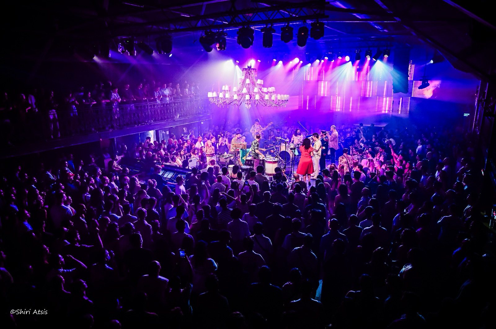 The Samba Project on stage in the middle of a packed, dancing crowd